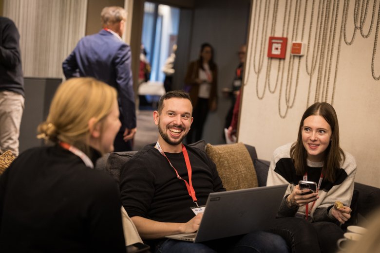 3 Personen unterhalten sich in einer Sitzecke