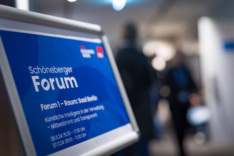 Ein Schild im Alurahmen, das vor einem Raum steht. Mit der Schrift: Schöneberger Forum - Forum 1