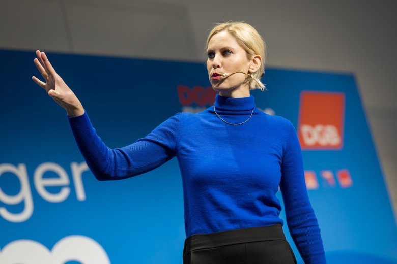 Gruppe reckt die Arme und steht vor einem blauen Rückwand mit dem Schriftzug Schöneberger Forum