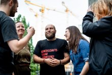 Menschen stehen in einem Kreis und unterhalten sich