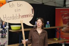 Frau hält ein Schild hoch auf dem steht: Ich bin ein Handelshemmnis.