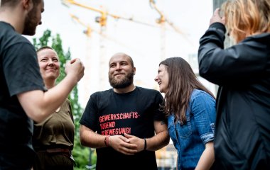 Menschen stehen in einem Kreis und unterhalten sich