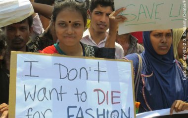 Protest von Arbeiter*innen in Bangladesch: Auf einem Schild steht: I don't want to die for fashion